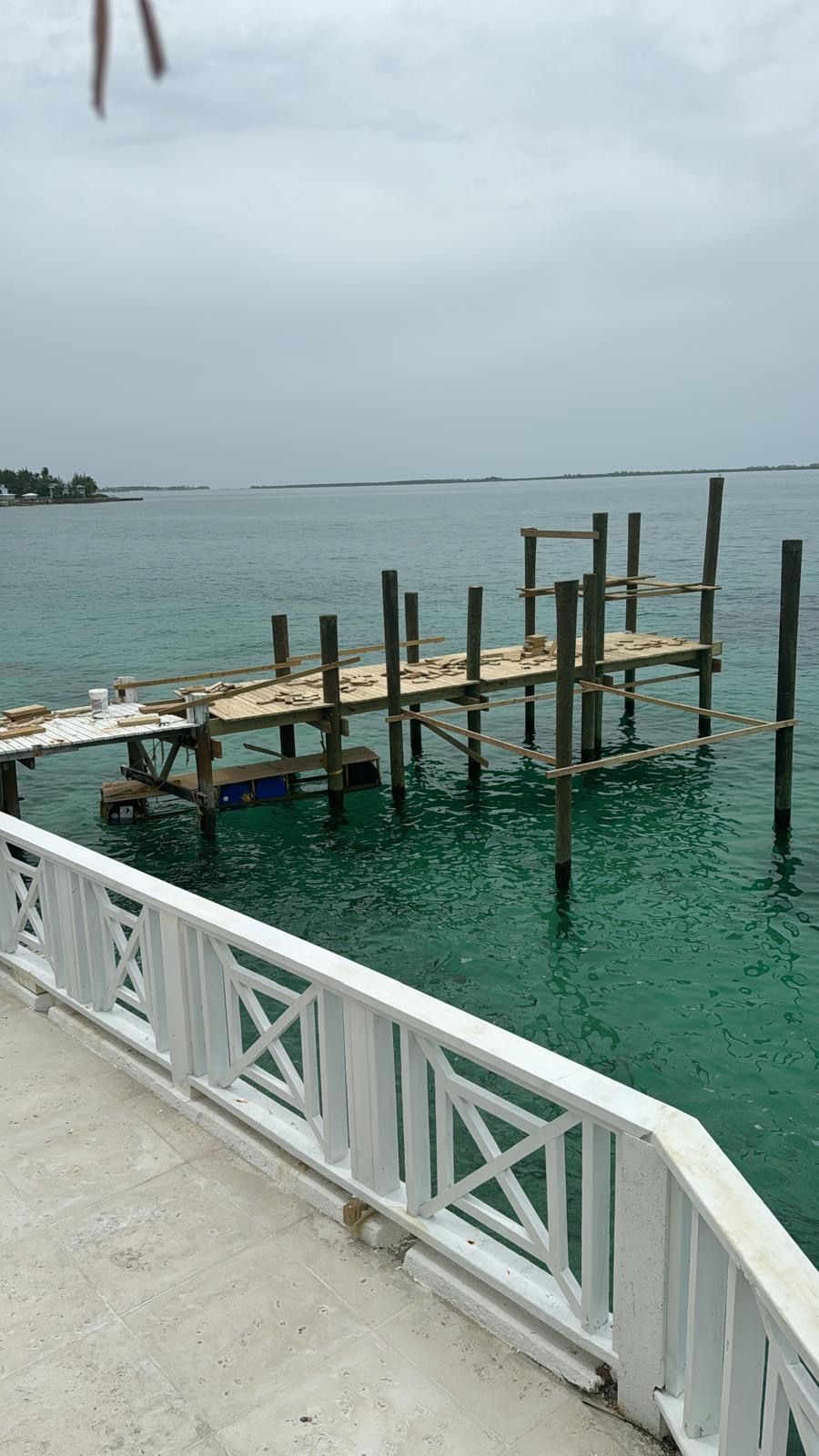 Timber dock under construction over turquoise water.